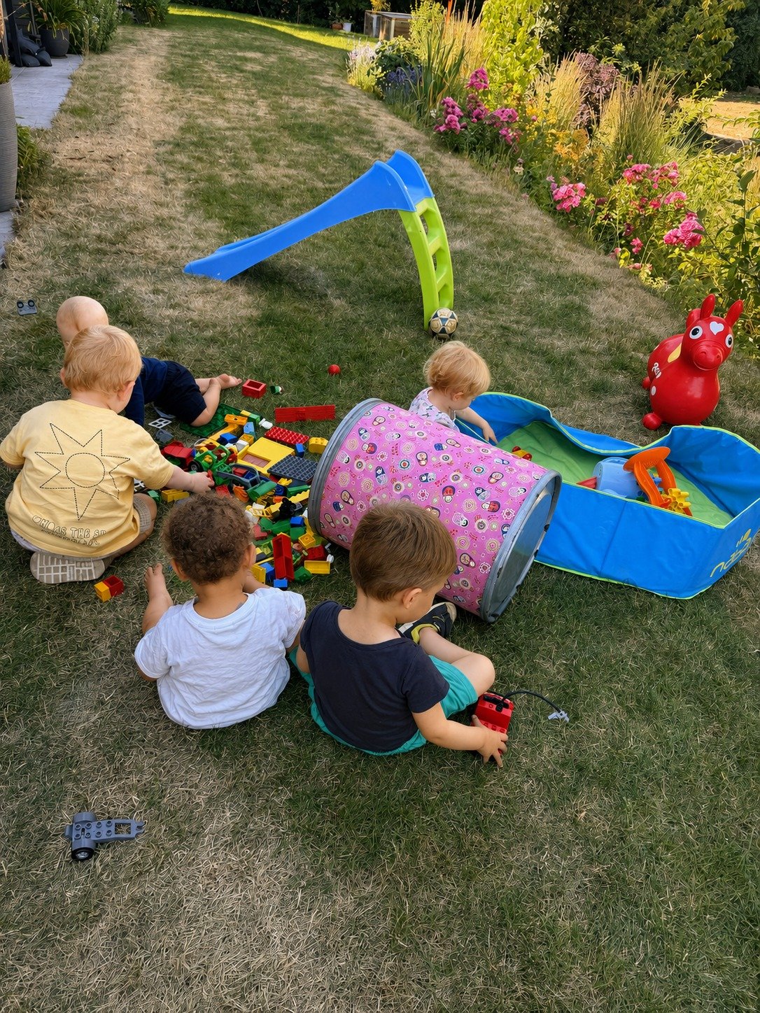 Kinder spielen im Garten der Kindertagespflege in Eisingen mit Rutsche, Bauklötzen und Kriechtunnel